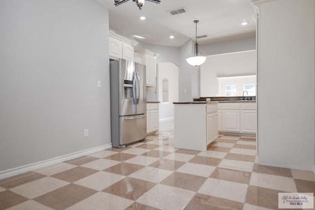 kitchen featuring decorative light fixtures, white cabinetry, stainless steel fridge with ice dispenser, and sink