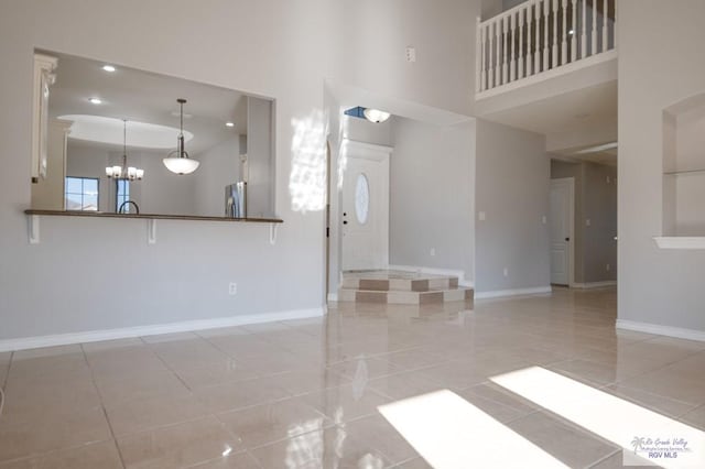6724 Pino Verde Dr, Brownsville, TX 78526 - unfurnished living room with recessed lighting, a towering ceiling, tile patterned floors, baseboards, and a chandelier