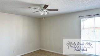 unfurnished room featuring baseboards, a ceiling fan, and tile patterned floors