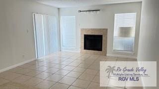 unfurnished living room featuring tile patterned flooring, baseboards, and a fireplace