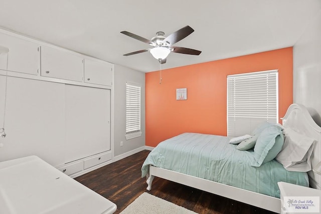 bedroom featuring dark wood-type flooring, ceiling fan, and a closet