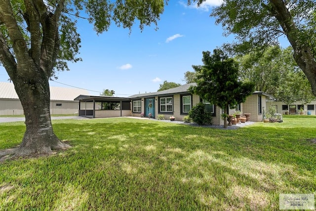 rear view of property with a carport and a yard