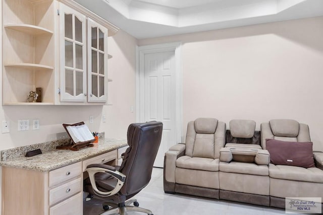 tiled office featuring built in desk, a raised ceiling, and ornamental molding