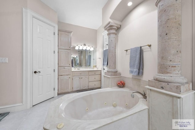 bathroom featuring tile patterned floors, ornate columns, a washtub, and vanity