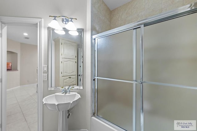 bathroom with tile patterned flooring and bath / shower combo with glass door