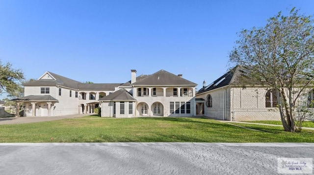 view of front of home featuring a front yard and a balcony