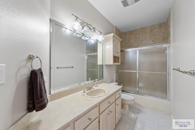 full bathroom featuring tile patterned flooring, vanity, bath / shower combo with glass door, and toilet