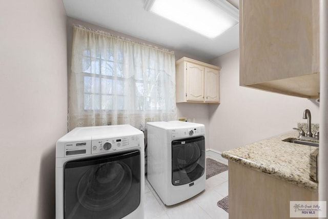 washroom with cabinets, light tile patterned floors, sink, and washing machine and clothes dryer