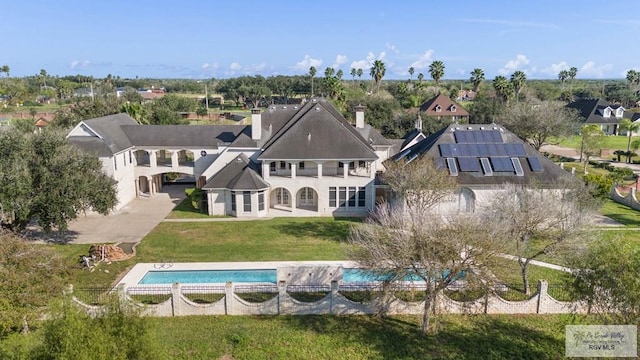 back of property featuring a lawn and solar panels