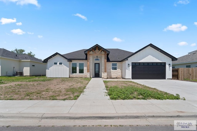 446 Parker Rd, La Feria, TX 78559 - modern farmhouse with a garage, fence, driveway, cooling unit, and stone siding