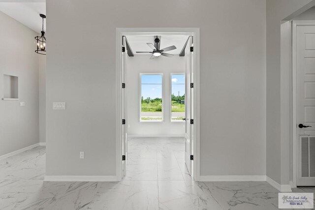 446 Parker Rd, La Feria, TX 78559 - hallway featuring light marble finish floors, baseboards, and a chandelier