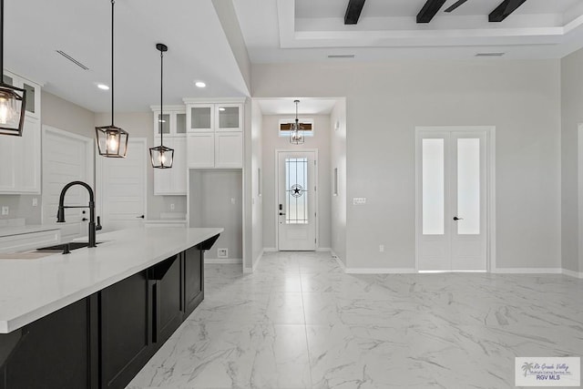 446 Parker Rd, La Feria, TX 78559 - kitchen with a sink, baseboards, glass insert cabinets, light countertops, and light marble finish floors