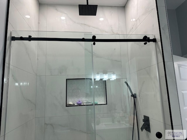 bathroom with a shower with door