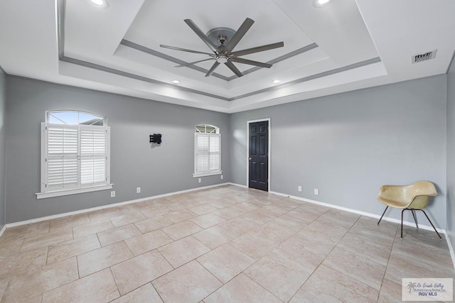 empty room with a tray ceiling and a healthy amount of sunlight