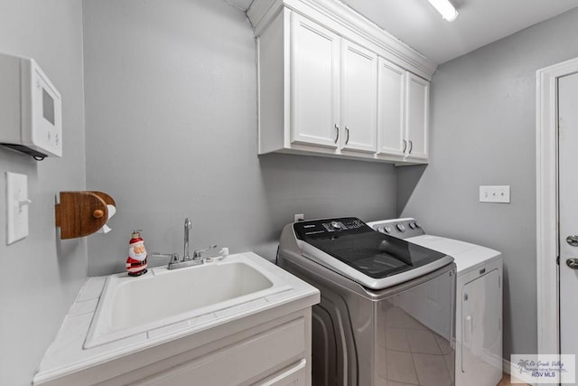 washroom with washer and clothes dryer, cabinets, and sink