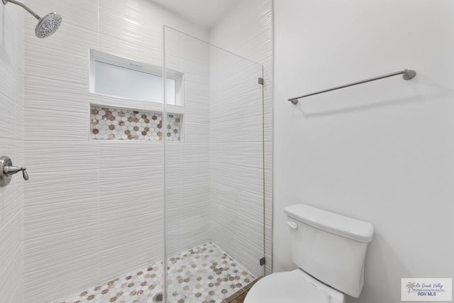 bathroom with tiled shower and toilet