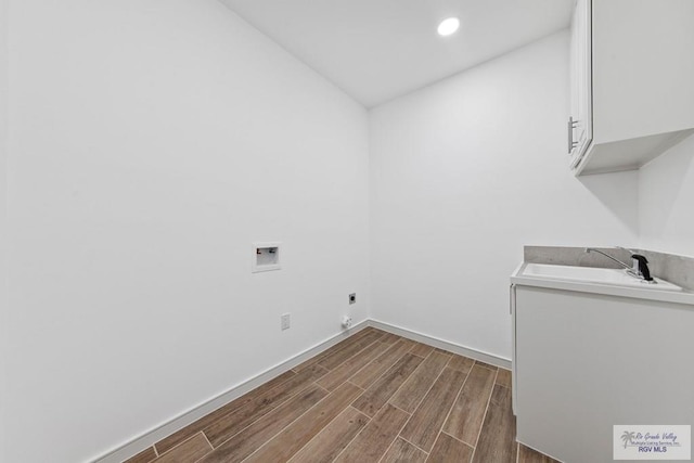 laundry room with cabinets, hookup for a washing machine, dark hardwood / wood-style flooring, hookup for an electric dryer, and sink