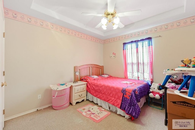 bedroom with carpet, ceiling fan, and a tray ceiling