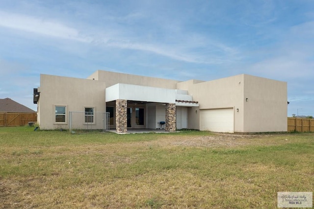 rear view of house featuring a garage and a yard