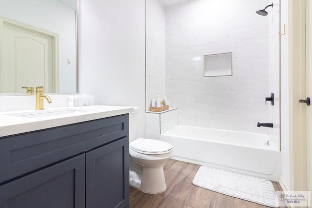 full bathroom with hardwood / wood-style floors, vanity, toilet, and tiled shower / bath combo