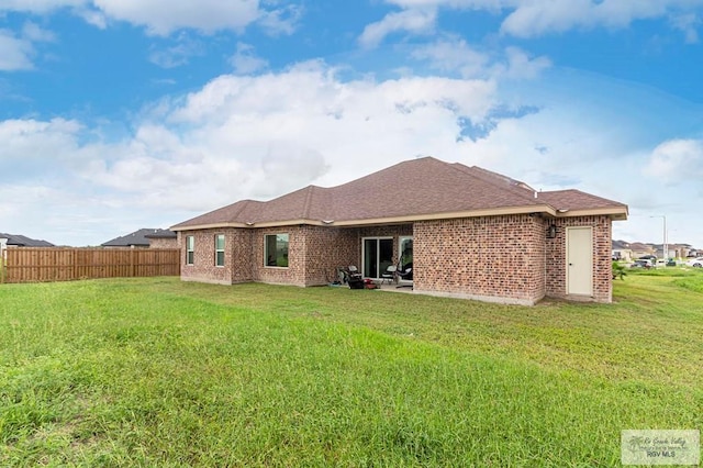 rear view of property with a patio and a lawn