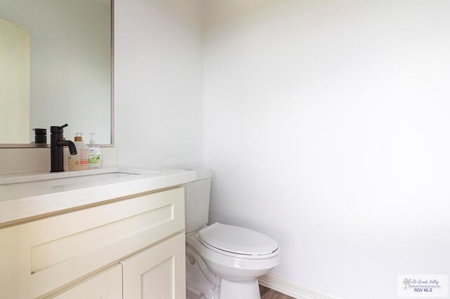 bathroom featuring hardwood / wood-style floors, vanity, and toilet