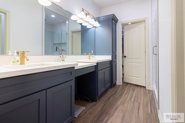 bathroom with vanity, hardwood / wood-style flooring, and walk in shower