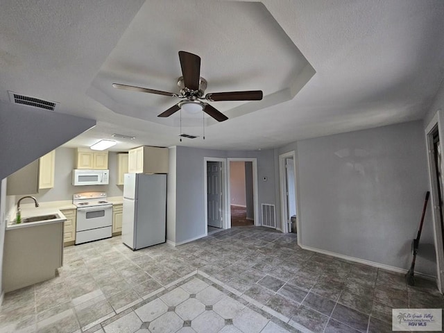 kitchen featuring a textured ceiling, white appliances, ceiling fan, and sink