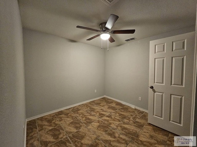 empty room with ceiling fan and a textured ceiling