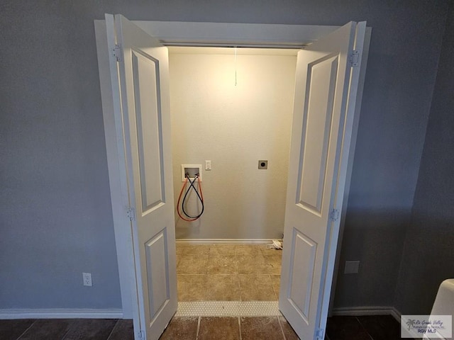 interior space with hookup for a washing machine, dark tile patterned floors, and hookup for an electric dryer