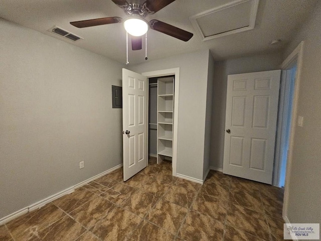 unfurnished bedroom with ceiling fan, electric panel, and a closet