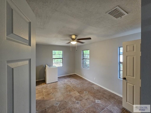 foyer featuring ceiling fan, dark tile patterned floors, and a textured ceiling