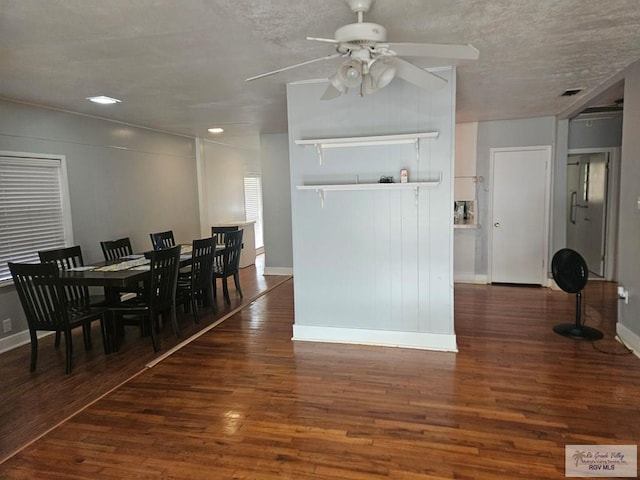 dining area featuring ceiling fan, dark hardwood / wood-style flooring, and a textured ceiling