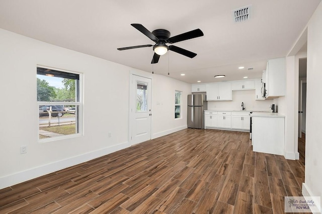 unfurnished living room featuring ceiling fan and sink