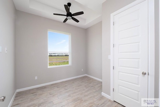 empty room with ceiling fan and light hardwood / wood-style floors