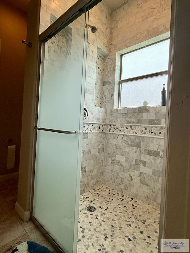 bathroom with tile patterned flooring and a shower with door