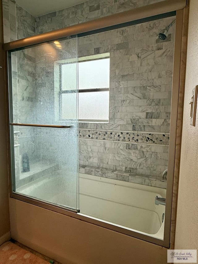 bathroom featuring combined bath / shower with glass door