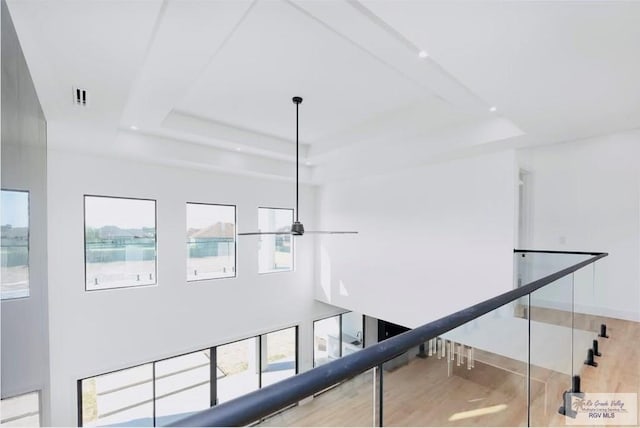 interior space with recessed lighting, wood finished floors, visible vents, baseboards, and a raised ceiling