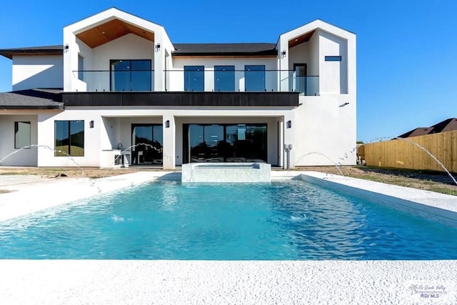 back of property with a patio, fence, a balcony, and stucco siding