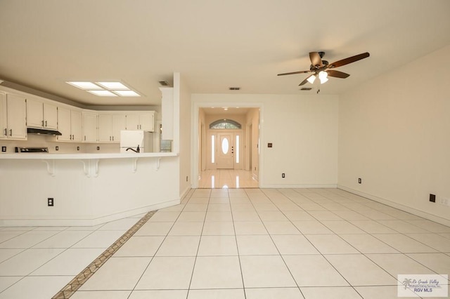 212 E Xenops Ave, Mcallen, TX 78504 - kitchen featuring under cabinet range hood, light countertops, a kitchen breakfast bar, open floor plan, and a ceiling fan