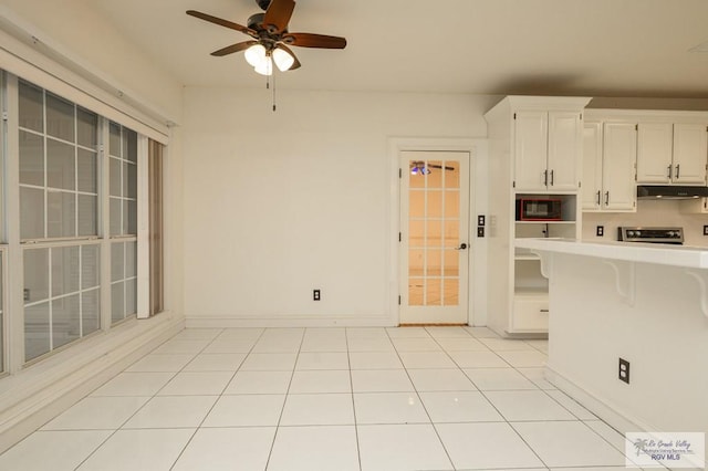 212 E Xenops Ave, Mcallen, TX 78504 - kitchen featuring light countertops, under cabinet range hood, white cabinets, ceiling fan, and a breakfast bar area