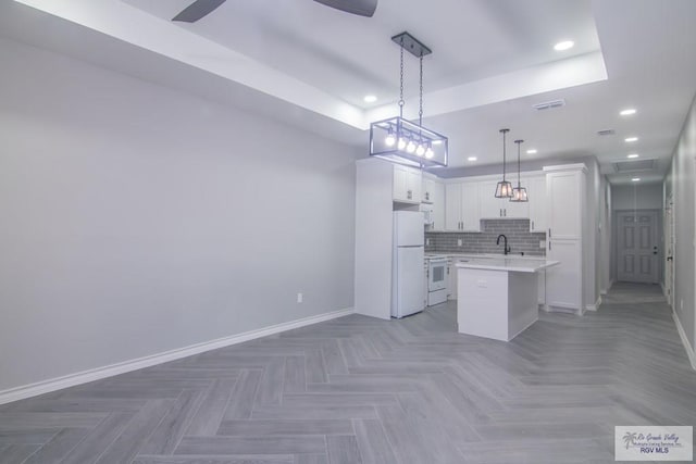 kitchen featuring white cabinetry, tasteful backsplash, decorative light fixtures, white appliances, and a kitchen island