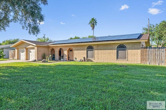 ranch-style home with solar panels, a garage, and a front lawn