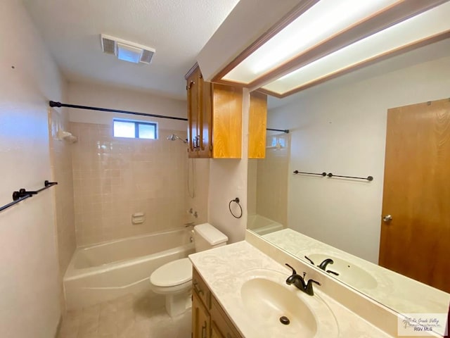 full bathroom with vanity, tiled shower / bath combo, and toilet