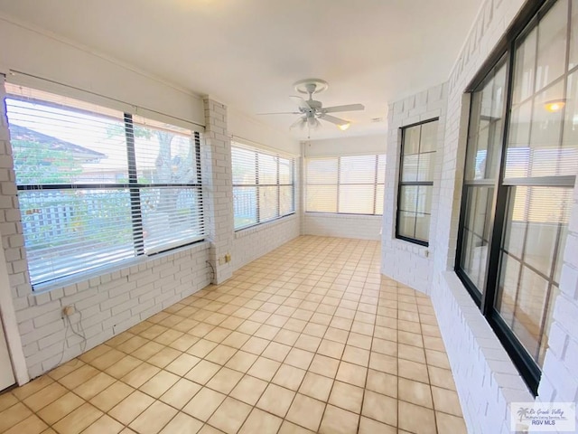 unfurnished sunroom with ceiling fan