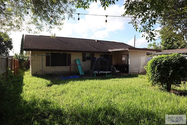 rear view of property with a trampoline