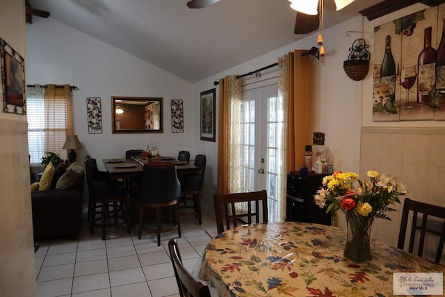 dining space featuring ceiling fan, lofted ceiling, light tile patterned floors, and french doors