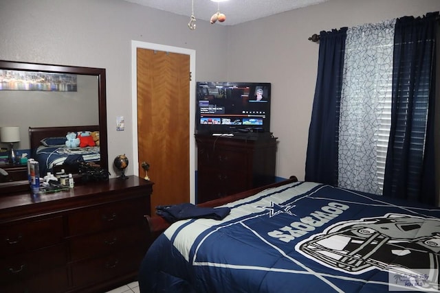 tiled bedroom featuring a textured ceiling