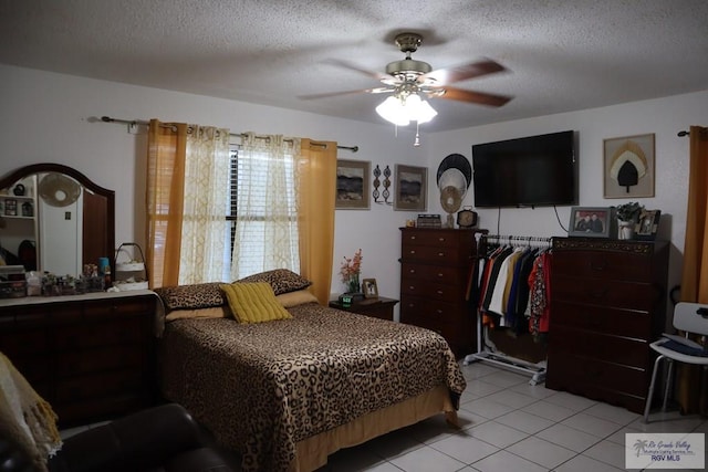 tiled bedroom with a textured ceiling and ceiling fan