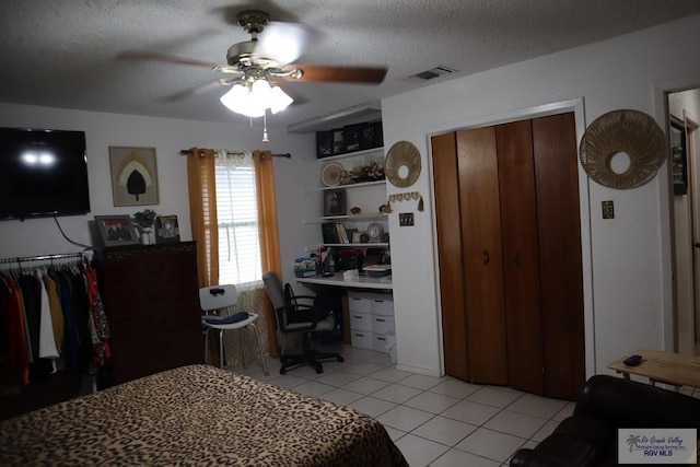 bedroom with light tile patterned floors, a textured ceiling, and ceiling fan